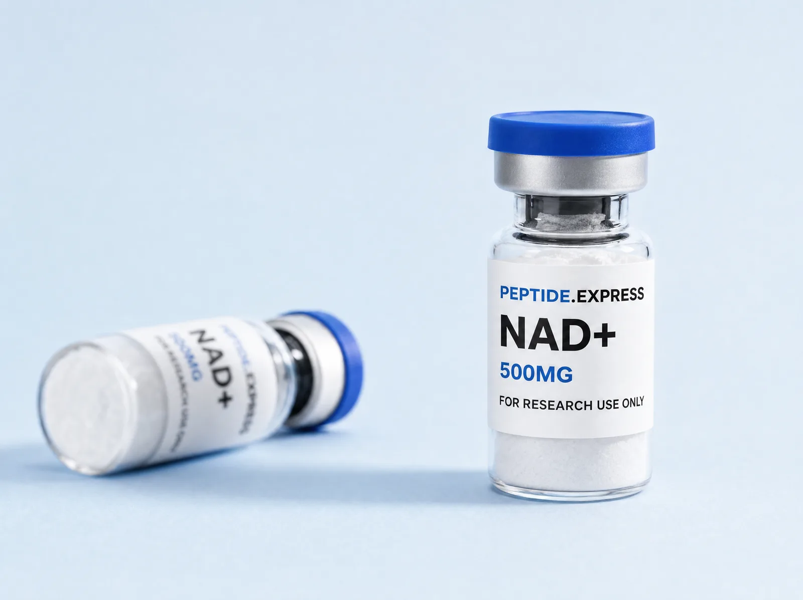 Two Peptide.Express NAD+ vials with white lyophilized powder at the base of each, standing side by side on a pale surface.